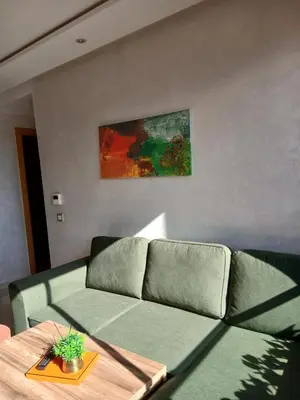 a living room with a green couch and a table at Studio meublé Guéliz in Marrakech