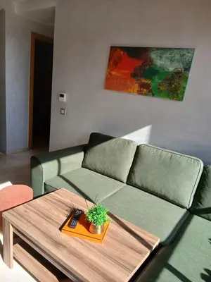 a living room with a green couch and a table at Studio meublé Guéliz in Marrakech