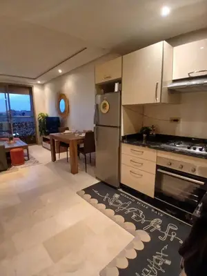 a kitchen with a refrigerator and a table at Studio meublé Guéliz in Marrakech