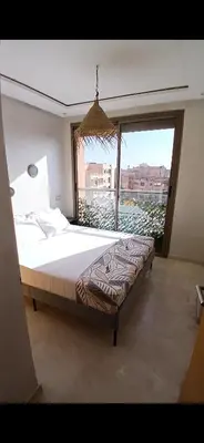 a bedroom with a large bed and a large window at Studio meublé Guéliz in Marrakech