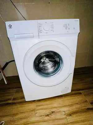 a white washing machine sitting on a wooden floor at Soman Marrakech in Marrakech