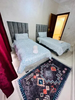 two beds in a room with a rug on the floor at Soman Marrakech in Marrakech
