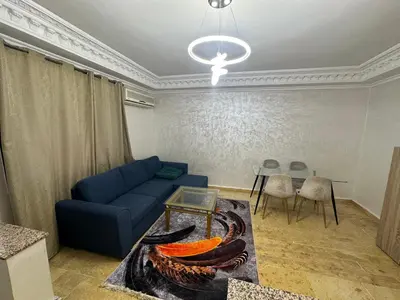 a living room with a blue couch and a table at Soman Marrakech in Marrakech