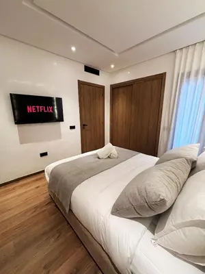 a bedroom with a bed with a television on the wall at New Apartment in Gueliz with Private Terrace in Marrakech