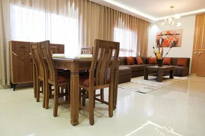 a living room with a wooden table and chairs at The Skybox your private seat at the city s show in Marrakech