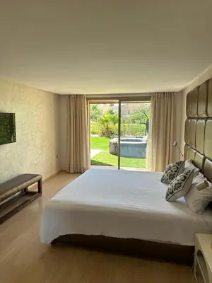 a bedroom with a large bed and a large window at Marrakech village -2 chambres jardin avec jacuzzi in Marrakech
