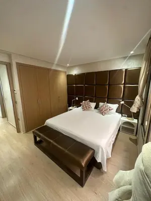 a bedroom with a large bed with a large headboard at Marrakech village -2 chambres jardin avec jacuzzi in Marrakech