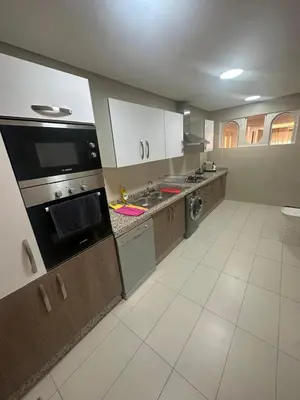 a kitchen with white cabinets and a stove top oven at Marrakech village -2 chambres jardin avec jacuzzi in Marrakech