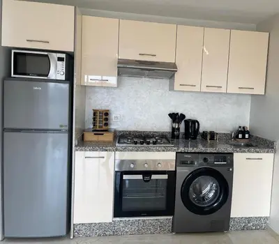 a kitchen with a refrigerator and a washing machine at Appartement luxe avec piscine in Marrakech