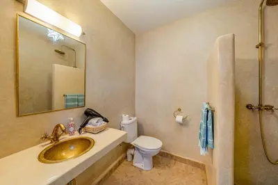 a bathroom with a sink and a toilet and a mirror at Riad JewelBox Exclusive Stay In the Medina in Marrakech