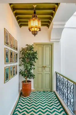 a hallway with a green door and a potted plant at Riad JewelBox Exclusive Stay In the Medina in Marrakech