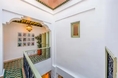 a hallway with white walls and a ceiling with a chandelier at Riad JewelBox Exclusive Stay In the Medina in Marrakech