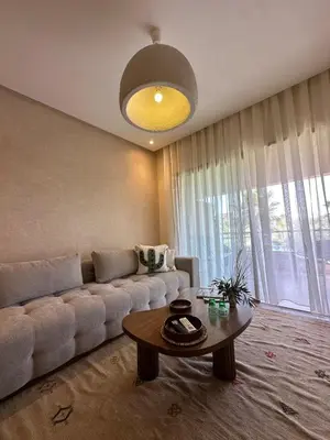 a living room with a couch and a table at Prestigia Jade Beautiful Apartment Marrakesh in Marrakech
