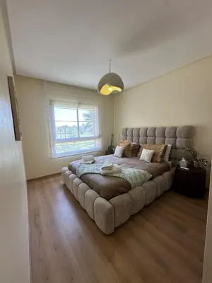 a large bed in a room with a large couch at Prestigia Jade Beautiful Apartment Marrakesh in Marrakech