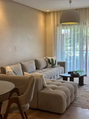 a living room with a couch and a table at Prestigia Jade Beautiful Apartment Marrakesh in Marrakech