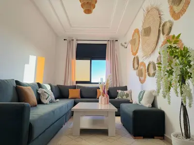 a living room with a blue couch and a table at Marrakech Cosy appartement 2 chambres - Confort in Marrakech