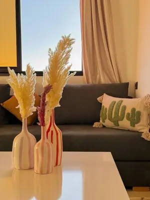 three vases sitting on a table in front of a couch at Marrakech Cosy appartement 2 chambres - Confort in Marrakech
