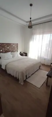 a white bedroom with a large bed and a window at Light filled Urban Retreat in Marrakech