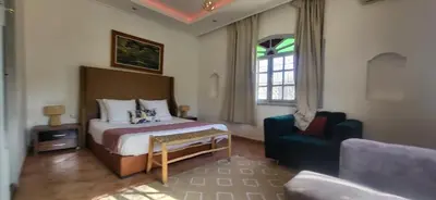 a bedroom with a bed and a couch and a chair at Villa Riad Dar Sukar in Marrakech