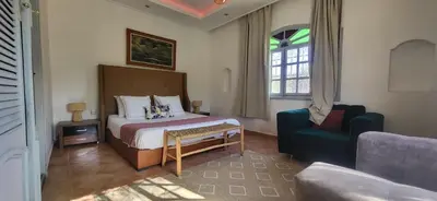 a bedroom with a bed and a couch and a chair at Villa Riad Dar Sukar in Marrakech