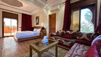 a living room with a couch and a bed at boulevard oued issil Palmeraie in Marrakech