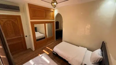 a small bedroom with a bed and a mirror at boulevard oued issil Palmeraie in Marrakech