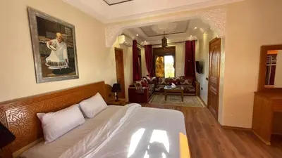 a bedroom with a bed and a living room at boulevard oued issil Palmeraie in Marrakech