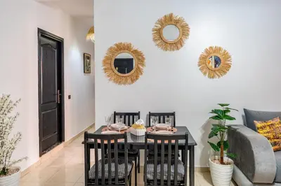a living room with a table and a couch and mirrors at Mabrouka apartment 10 minutes from Guéliz in Marrakech