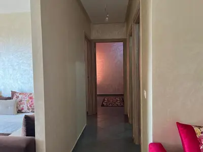 a hallway with a room with a bed and a window at Cozy & Modern Apartment Minutes from Menara Airport in Marrakech