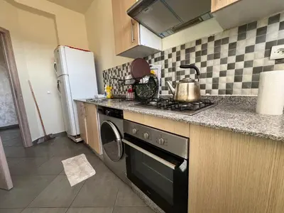 a kitchen with a stove and a refrigerator at Cozy & Modern Apartment Minutes from Menara Airport in Marrakech