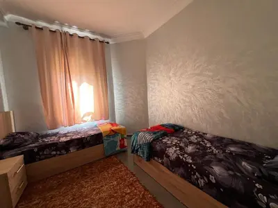 a bedroom with two beds and a window at Cozy & Modern Apartment Minutes from Menara Airport in Marrakech
