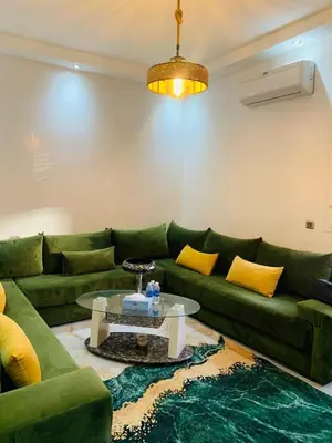 a living room with a green couch and a table at appartement lumineux parfait Cosy prêt de Guéliz in Marrakech