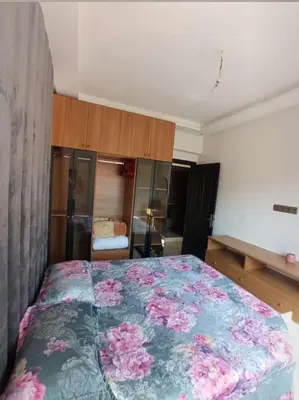 a bedroom with a bed with a floral bedspread at appartement lumineux parfait Cosy prêt de Guéliz in Marrakech