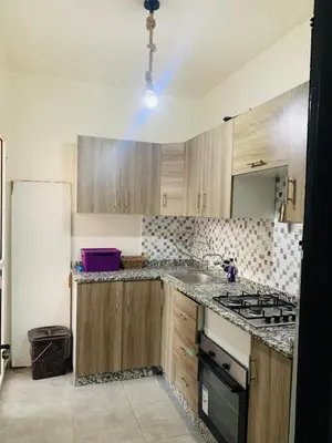 a kitchen with wooden cabinets and a stove top oven at appartement lumineux parfait Cosy prêt de Guéliz in Marrakech