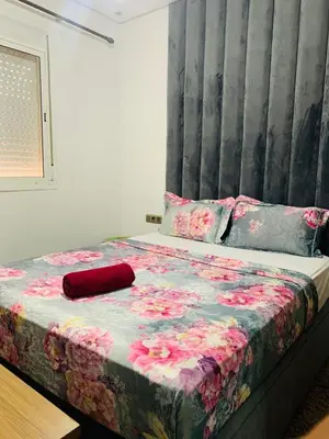 a bedroom with a bed with a flower patterned blanket at appartement lumineux parfait Cosy prêt de Guéliz in Marrakech