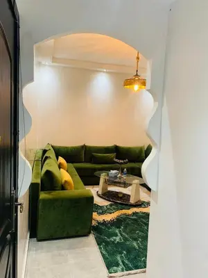 a living room with a green couch and a table at appartement lumineux parfait Cosy prêt de Guéliz in Marrakech