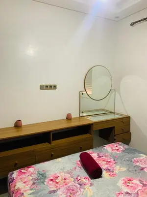 a bedroom with a dresser and a mirror and a bed at appartement lumineux parfait Cosy prêt de Guéliz in Marrakech
