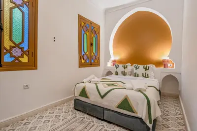 a bedroom with a bed with an arch above it at Riad Cherifa Breakfast and Jacuzzi Terrace in Marrakech