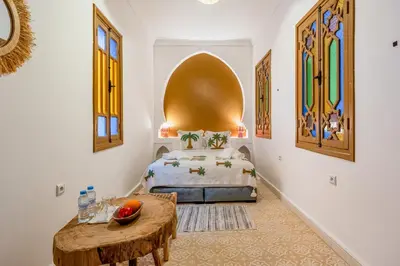 a bedroom with a bed and a table in it at Riad Cherifa Breakfast and Jacuzzi Terrace in Marrakech