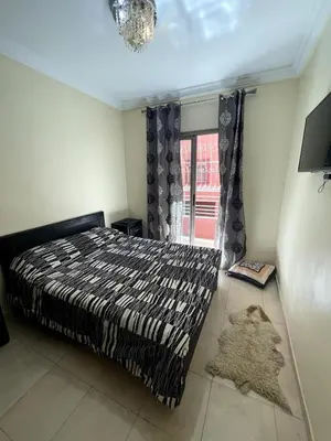 a bedroom with a bed and a window and a rug at Le petit Marrakchi in Marrakech