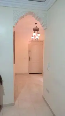 a hallway with a white door and a chandelier at Le petit Marrakchi in Marrakech