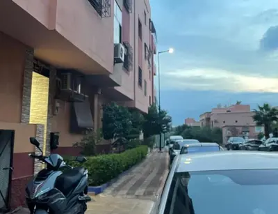 a car parked next to a building with a motorcycle at Le petit Marrakchi in Marrakech