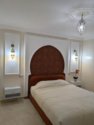 a bedroom with a large bed and two lights at Majorelle Terracotta Spa in Marrakech