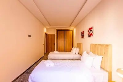 two beds in a room with white sheets at Marrakesh 2 BR Apartment in Marrakech