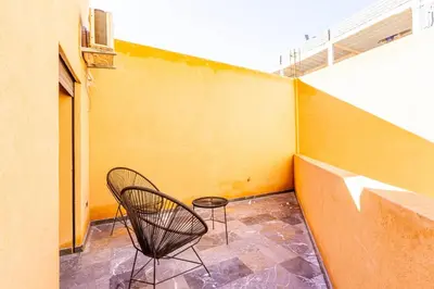 a chair sitting on a balcony next to a wall at Marrakesh 2 BR Apartment in Marrakech
