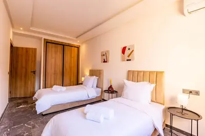 two beds in a room with white walls at Marrakesh 2 BR Apartment in Marrakech