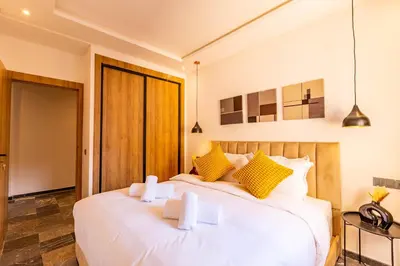 two beds in a bedroom with yellow and white pillows at Marrakesh 2 BR Apartment in Marrakech