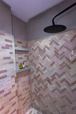 a bathroom with a shower with a mosaic wall at Maison beldi loft in Marrakech