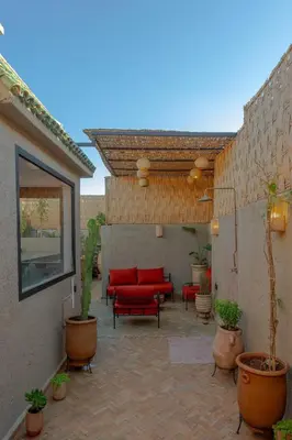 a patio with red couches and potted plants at Maison beldi loft in Marrakech