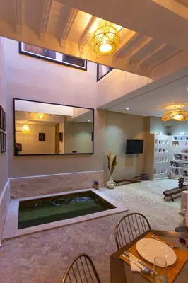 a large living room with a large mirror and a pool at Maison beldi loft in Marrakech